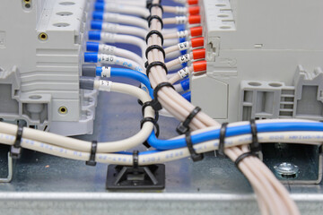 Connecting electrical modules using insulated wires in an electrical distribution cabinet. Close-up.