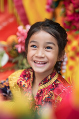 Wall Mural - Young girl in traditional clothing, smiling with vibrant colors in the background