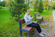 © Sergey - Mature man with mobile phone resting after workout in park