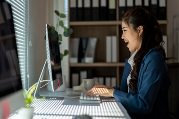 Wall Mural - A woman is sitting at a desk with a computer monitor