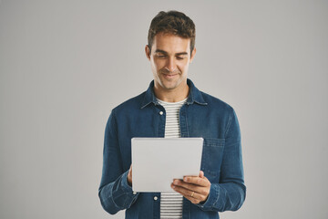 Poster - Ecommerce, smile and tablet with man in studio isolated on gray background for app download or update. Search, social media and website with happy user in casual outfit for online shopping or retail