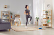 © Studio Romantic - Woman runs in place as part of her home workout session. She focuses on fitness and cardio training, staying active and healthy through regular jogging, running and sport in home gym.