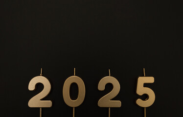 2025 Happy New Year. Top view of gold numbers on black background. Copy space, flat lay.