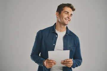 Poster - Idea, smile and tablet with man in studio isolated on gray background for app download or update. Ecommerce, social media and thinking with happy user in casual outfit for online shopping or retail