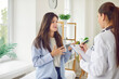 © Studio Romantic - A young woman in a clinic talks to a doctor about her health, close-up. Woman doctor listens to patient and writes down symptoms. Concept medical consultation and diagnosis of disease