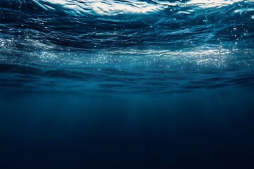 Wall Mural - sunlight shining through the water surface of deep blue ocean background with empty space for edit a