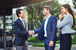 © peopleimages.com - Business, people and happy with handshake outside with welcome, greeting and introduction. Woman, men and smile as employees with shaking hands for collaboration, partnership or agreement on deal