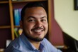 © Jaemie - Portrait of a Smiling Belizean Man in a Cozy Indoor Setting with Colorful Bookshelves