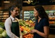 © Alexandra - Smiling shop assistant helping customer choosing groceries in the fruit and vegetable section of a supermarket