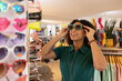 © ReeldealHD images - Young adult female trying on sunglasses in a store on vacation