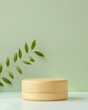 © mikeosphoto - Natural wood round pedestal set against a soft green background, accented with fresh green leaves. Ideal for eco-friendly, nature-inspired product displays with a calm aesthetic.