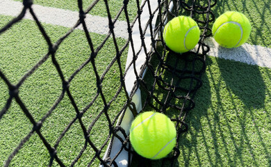 paddle tennis balls next to the net of a paddle tennis court