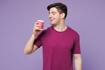 Poster - Young smiling happy Caucasian man he wears violet t-shirt casual clothes hold takeaway delivery craft paper brown cup coffee to go isolated on plain pastel light purple background. Lifestyle concept.