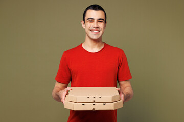 Young smiling happy cheerful middle eastern man he wear red t-shirt casual clothes hold stack of pizza in cardboard flatbox isolated on plain pastel green background studio portrait Lifestyle concept