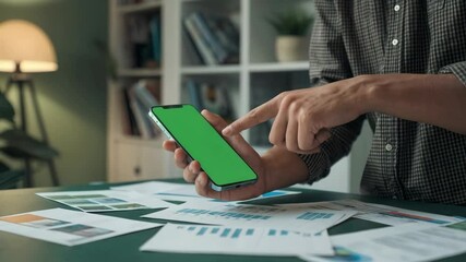 Poster - A person interacts with a green-screen smartphone amidst business documents.