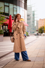 Wall Mural - Attractive mid aged woman standing on the street and using her smarpthone