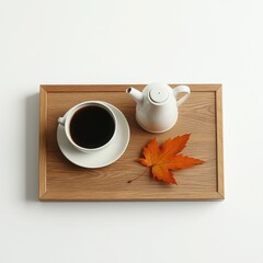 Coffee cup with teapot and autumn leaf on wooden tray, white isolated background