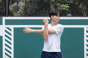 Young Athlete Stretching on Outdoor Basketball Court