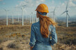 © sofiko14 - Caucasian female engineer inspecting wind turbines at a wind farm