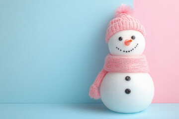 A snowman with a pink hat and scarf is standing on a blue background. The snowman has a happy expression on its face