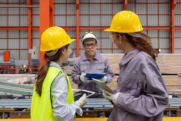 Engineers Overseeing Metal Sheet Production in Factory