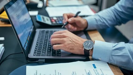 Poster - a person working on a laptop with documents and a calculator on a desk.