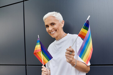 Joyful celebration of pride with vibrant flags in a modern urban backdrop.