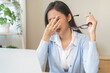 © KMPZZZ - Exhausted, asian young business woman working at office desk, took off eye glasses, massage rubbing nose from dry eyes, suffer on work hard, using laptop computer at office home, problem overtime job.