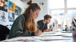 © Surachetsh - young individuals working on a project, with hands writing and sticky notes scattered, is ideal for promoting project management and business services.