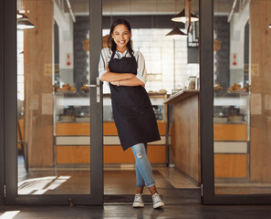 Portrait, happy woman and cafe owner with arms crossed for pride, hospitality and welcome to small business. Smile, coffee shop and confident entrepreneur, waitress and barista by door in Argentina