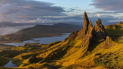 Wall Mural - epische Landschaft am Old man of Storr, Nahaufnahme zu Sonnenaufgang, seitlich zieht nebel ins Bild, Loch im Hintergrund