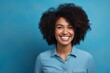 © Markus Schröder - Portrait of a smiling afro-american woman in her 40s sporting a versatile denim shirt over solid color backdrop