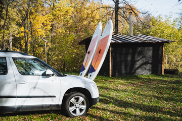 A white SUV that features two surfboards secured on the back of it, ready for an adventure at the beach or a fun day out on the waves, showcasing both functionality and style