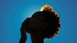 © SOUND OF RAIN - Silhouette of a Woman with Afro Hair Against a Blue Sky