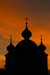 Silhouette of an Orthodox church against the background of the setting sun.