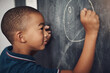 © peopleimages.com - Chalkboard, circle and education with boy student in classroom of school for growth or learning. Blackboard, development and drawing with child in lesson for academic knowledge or scholarship
