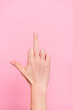 © deagreez - Close up cropped vertical photo of woman hand demonstrate middle finger isolated on pink color background
