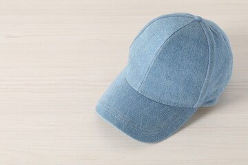 Wall Mural - Stylish denim baseball cap on wooden table. Mockup for design