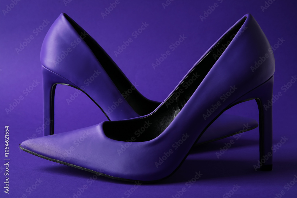 Stylish purple high heels on color background