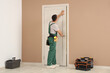 © Pixel-Shot - Male worker with tools examining door at home