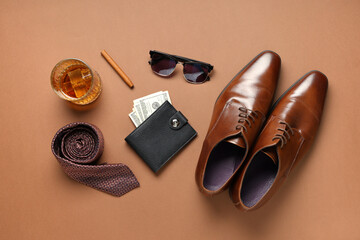 Wall Mural - Stylish men's accessories with shoes and glass of whiskey on brown background