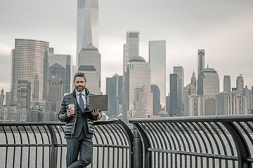 Businessman drink coffee. Businessman walk in business district at Manhattan. Businessman in a suit standing in front of a office building in New York City. Outdoor portrait of Hispanic businessman.