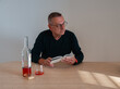 © Plamen - A man with a book in hands alone at table with bottle and half empty glass of wine