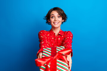 Wall Mural - Portrait of nice young girl give present you wear red xmas new year shirt isolated on blue color background