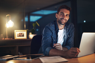 Leinwandbilder - Businessman, laptop and happy for project management, networking and communication in office at night. Employee, technology and portrait for proposal, report or research with late deadline completion
