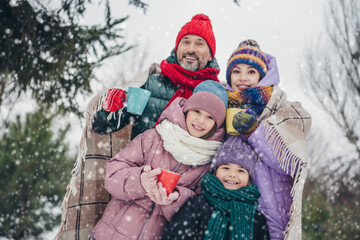 Poster - Photo of full peaceful cheerful family shoulders covered blanket hold hot tea mug walk snowy weather outdoors