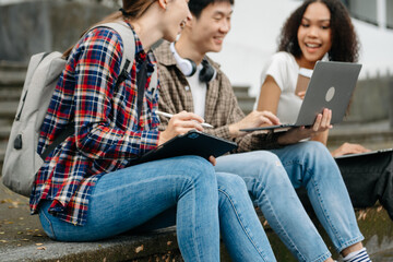 Cheerful group of diverse college students in casual attire walking together, enjoying campus life, and engaging in conversation. 
