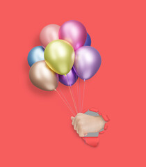 Childrens hand holding shiny colorful balloons through the hole in red paper