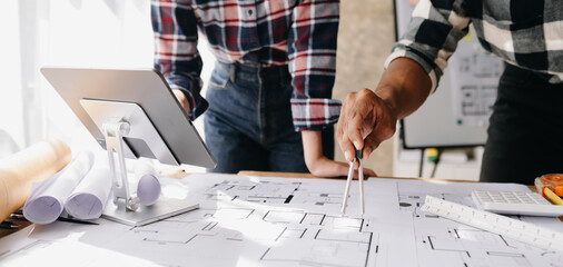 Wall Mural - creative architect projecting on the big drawings in the dark loft office or cafe in morning light..