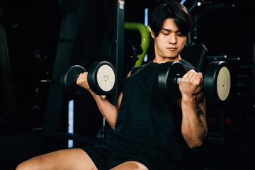 Asian man muscular lifting dumbbell on bench in fitness gym, Happy young men doing strength training press exercise with dumbbells in a gym, workout weight training healthy lifestyle concept